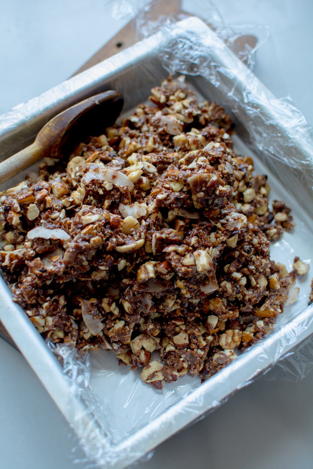 spooning nut bars into baking pan