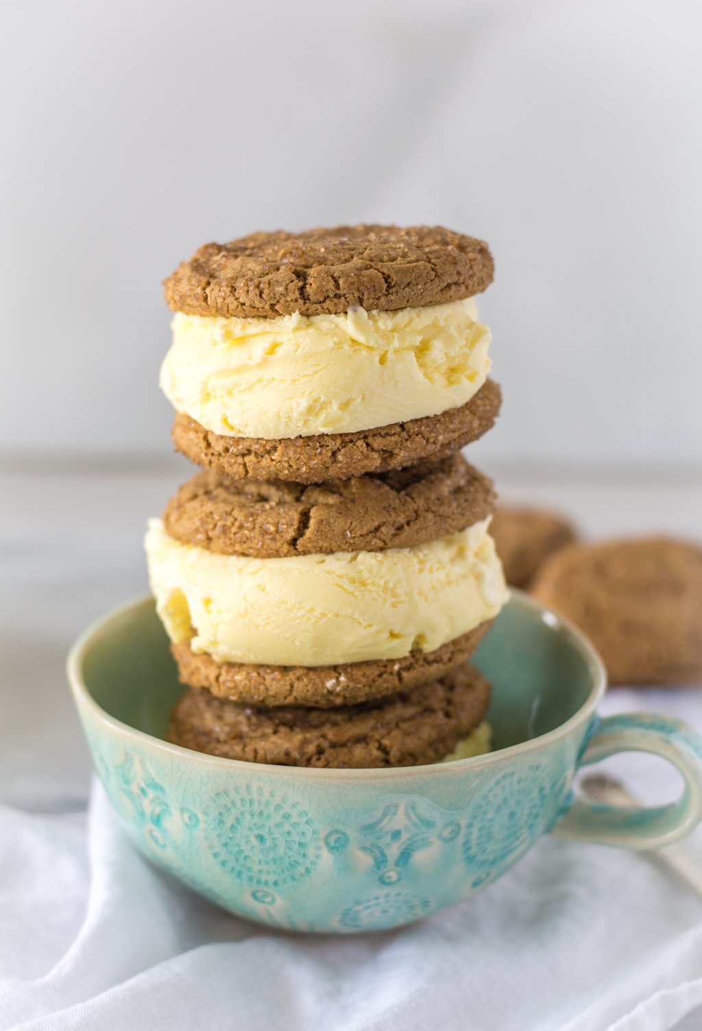 stacked lemon curd ice cream sandwiches in a green tea cup