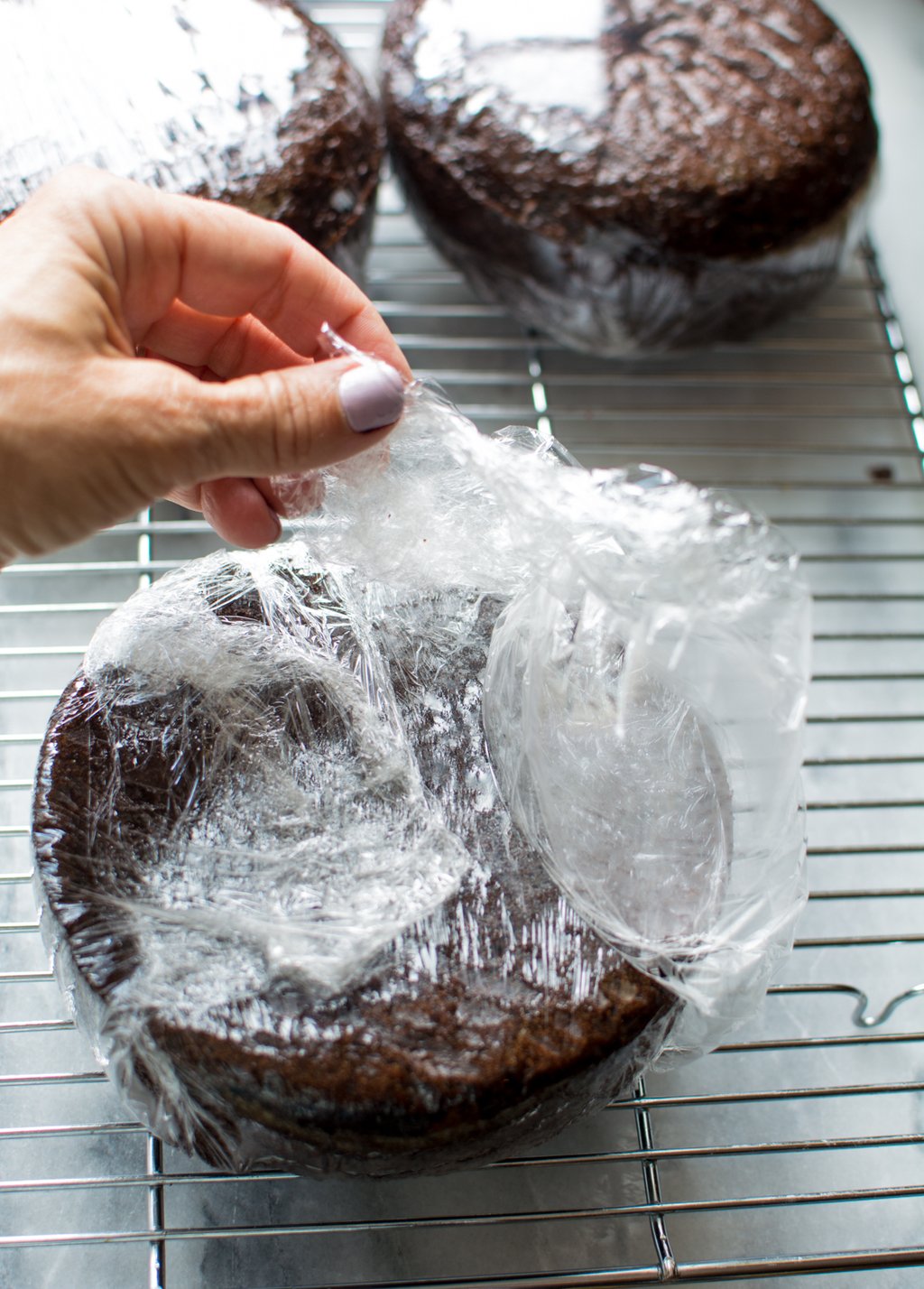 Round chocolate cake wrapped in plastic wrap