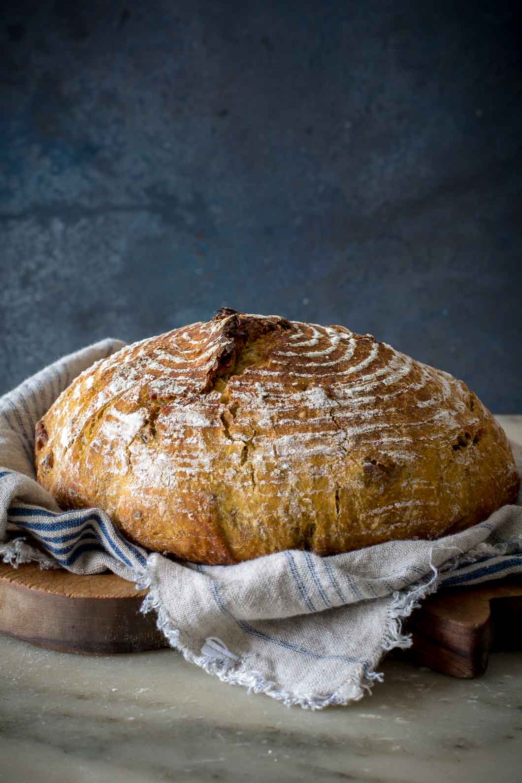 o-Knead Pumpkin Pecan Bread on a cutting board with a cloth underneath