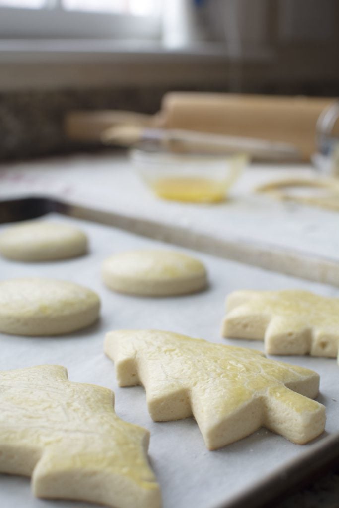 Baked christmas tree shaped sugar cookies on a metal baking pan.