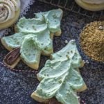 Tree cut out sugar cookies with green icing and golden sprinkles