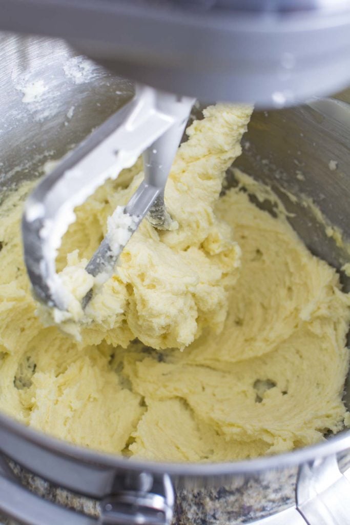 Blending cookie dough in a metal bowl.
