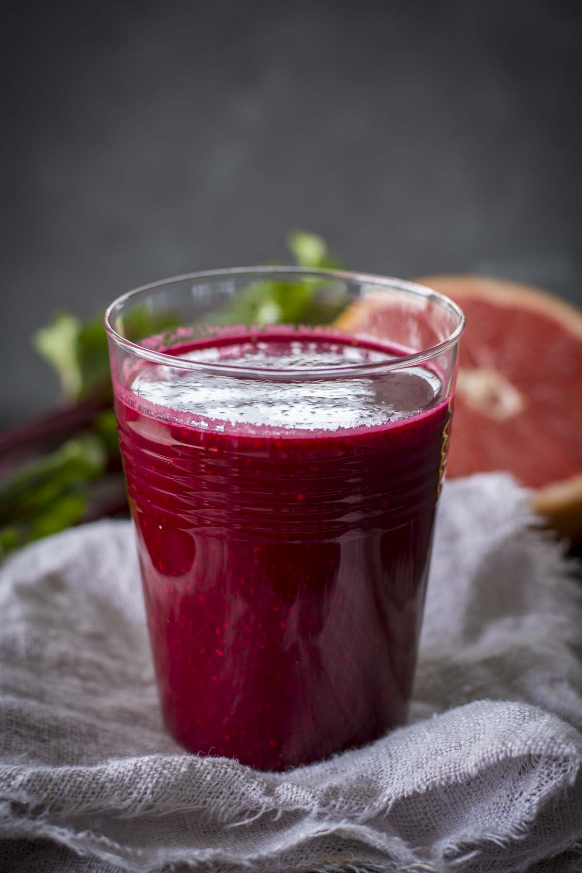 chia beet grapefruit juice in a glass with grapefruit in background