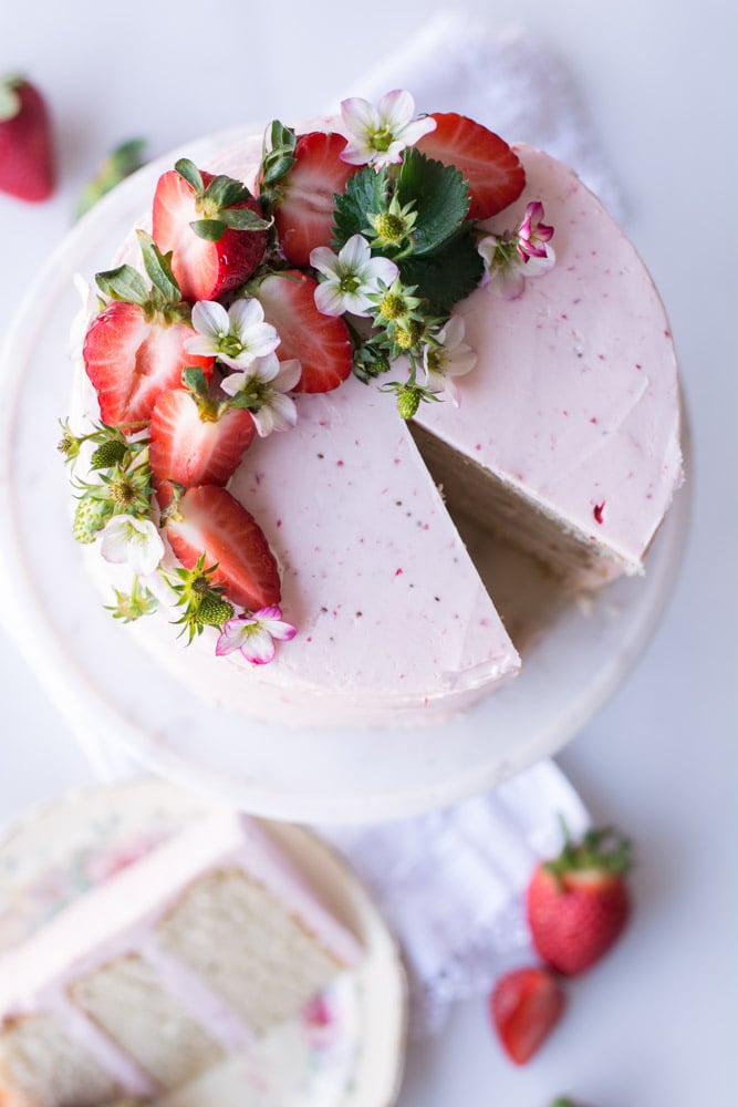 overhead shot of strawberry iced cake with strawberries on top