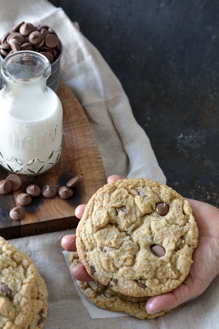 One large jumbo size chocolate chip cookie in hand for size comparison