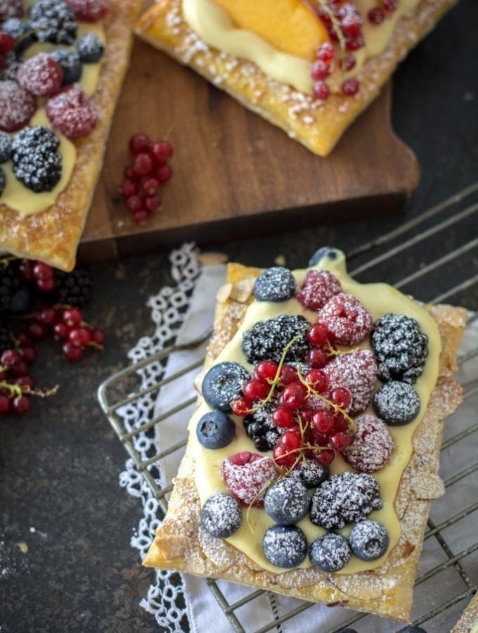 Easy Fresh Berry Puff Pastry Tarts on a cooling rack with white cloth