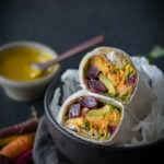 black bowl with Wrap with Turmeric Tahini Sauce in a black bowl