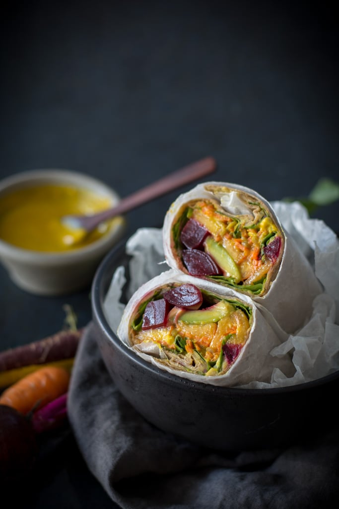 Beet, Peach, and Avocado Wrap with Turmeric Tahini Sauce in a black bowl