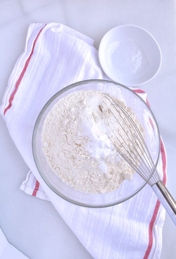 Flour being sifted in bowl for jumbo chocolate chip cookies