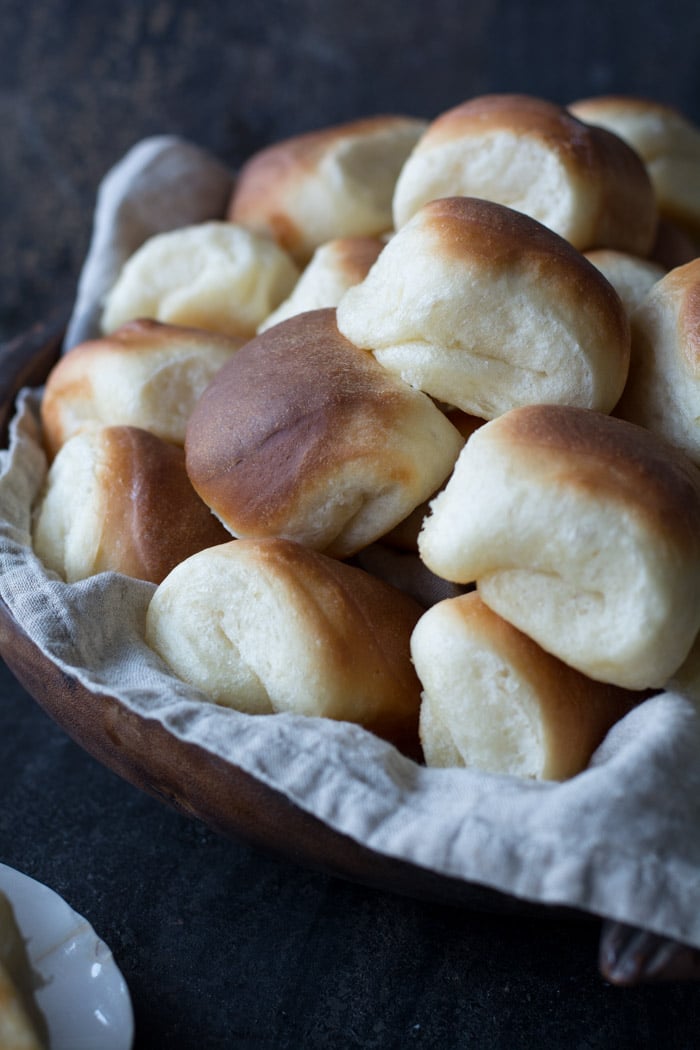 Buttery Parker House Rolls in a wooden bowl