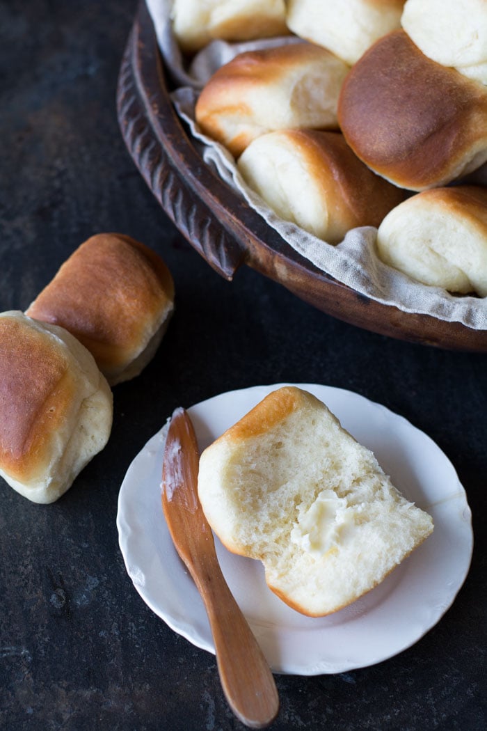 Buttery Parker House Rolls open with butter