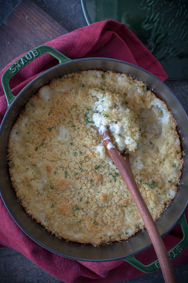 Baked macaroni and cheese with a wooden spoon