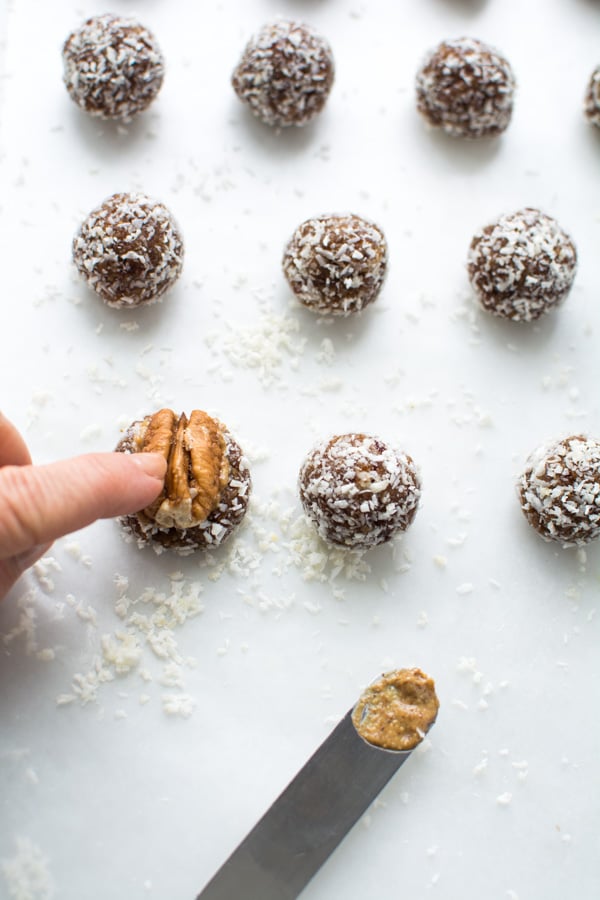 pressing pecan into date bites