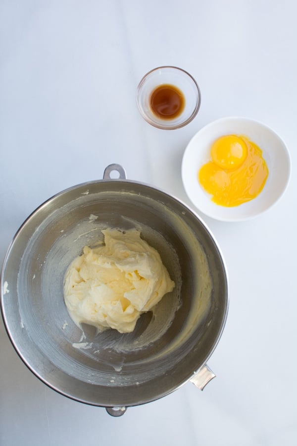 Bowl with butter mixture, egg yolks, vanilla, in bowl