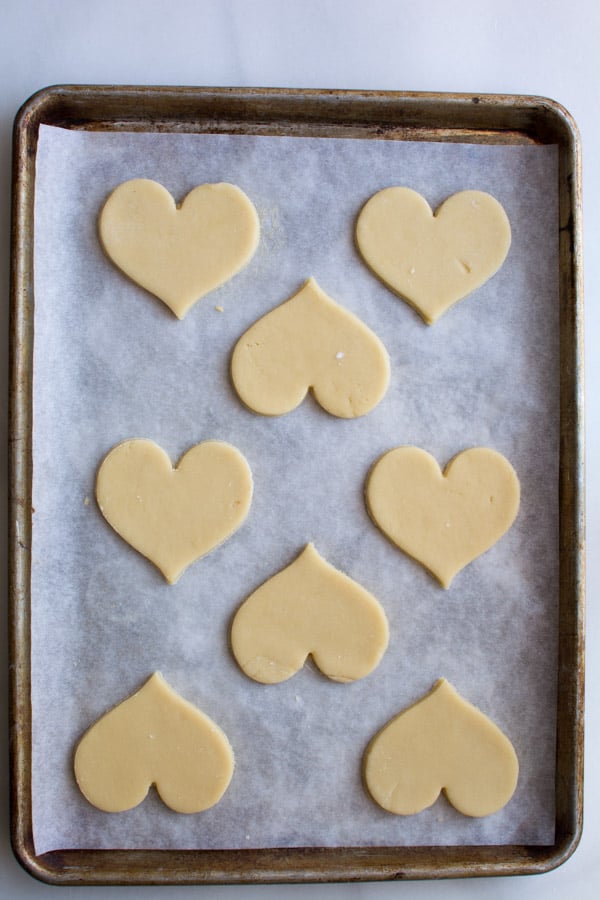 heart shaped cookie dough on baking sheet