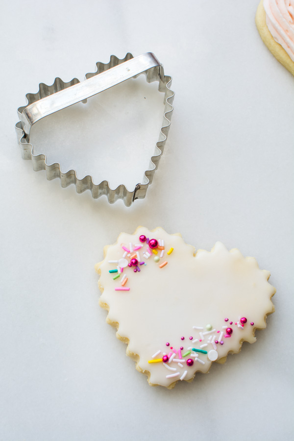 heart shaped sugar cookie with sprinkles and cutter