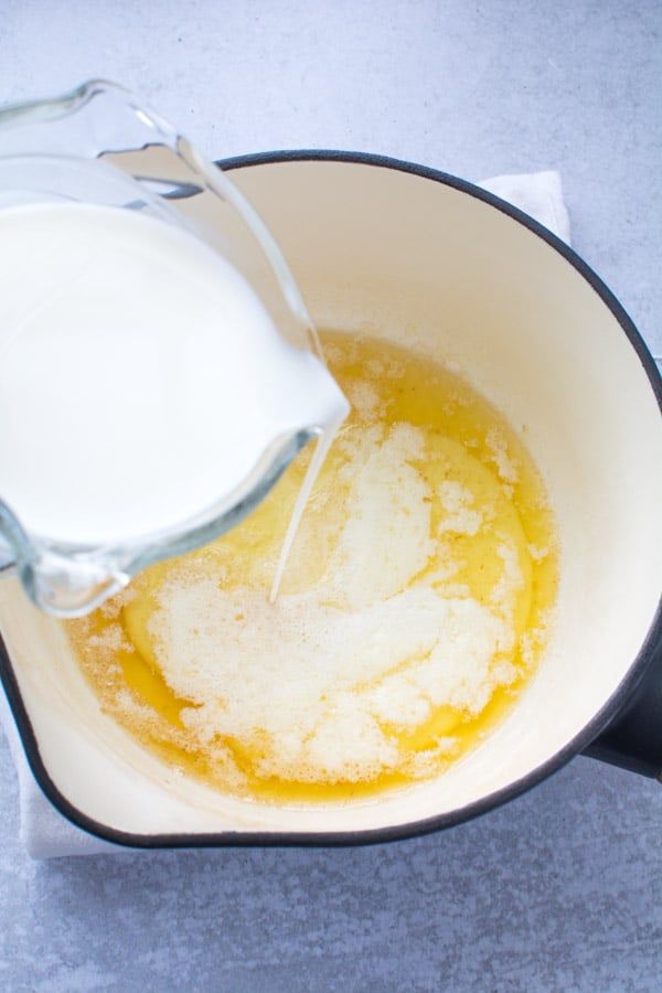 melted butter in a pot with milk pouring in