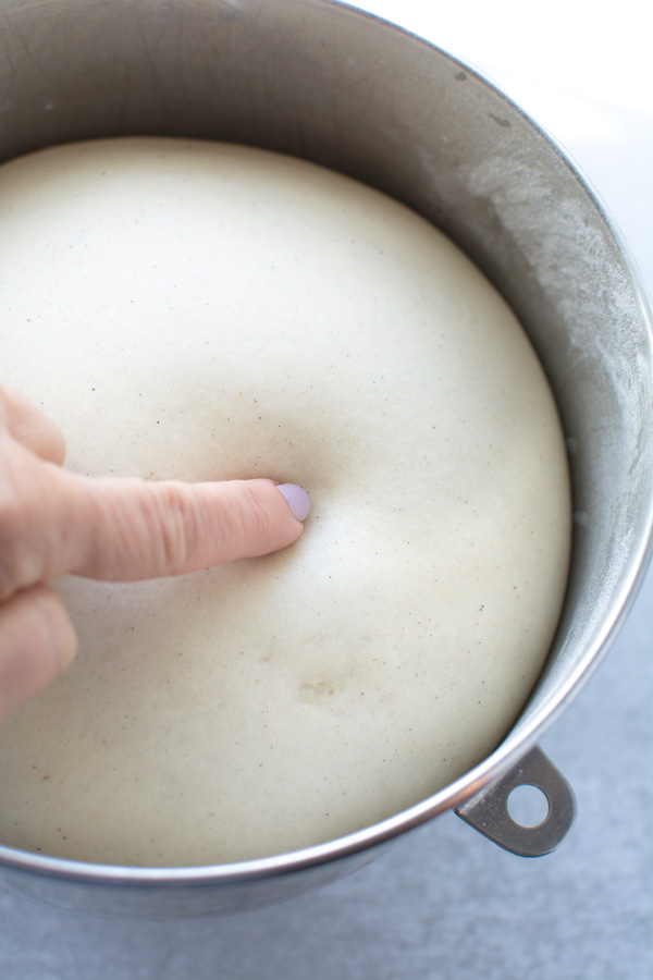 finger poking risen dough