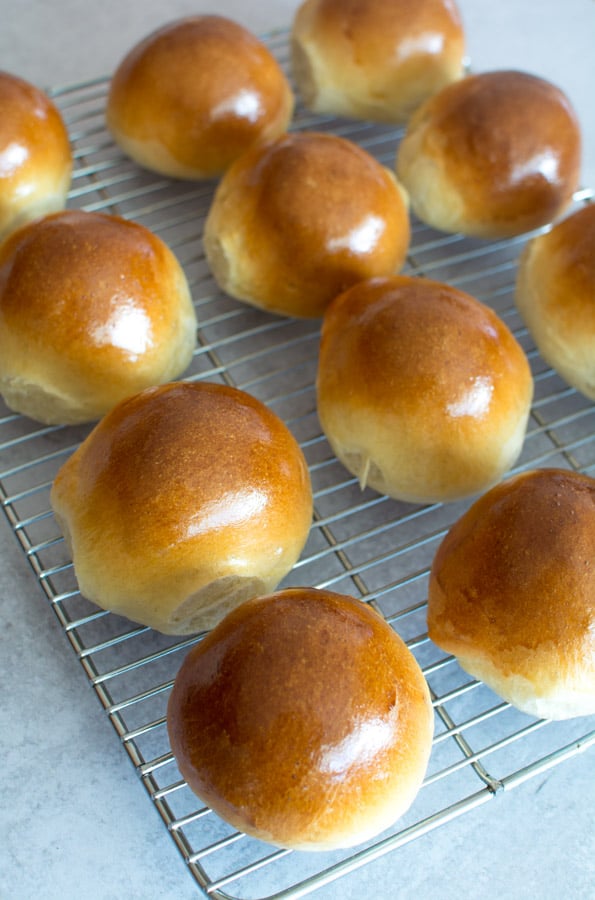 Baked Semlor Buns on a wire cooling rack.