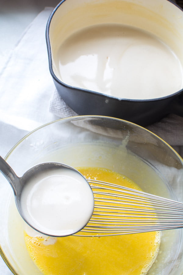 hot cream ladled into egg yolks