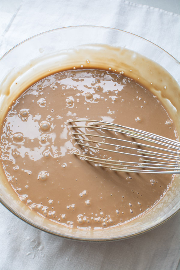 milk chocolate ice cream base in bowl with whisk