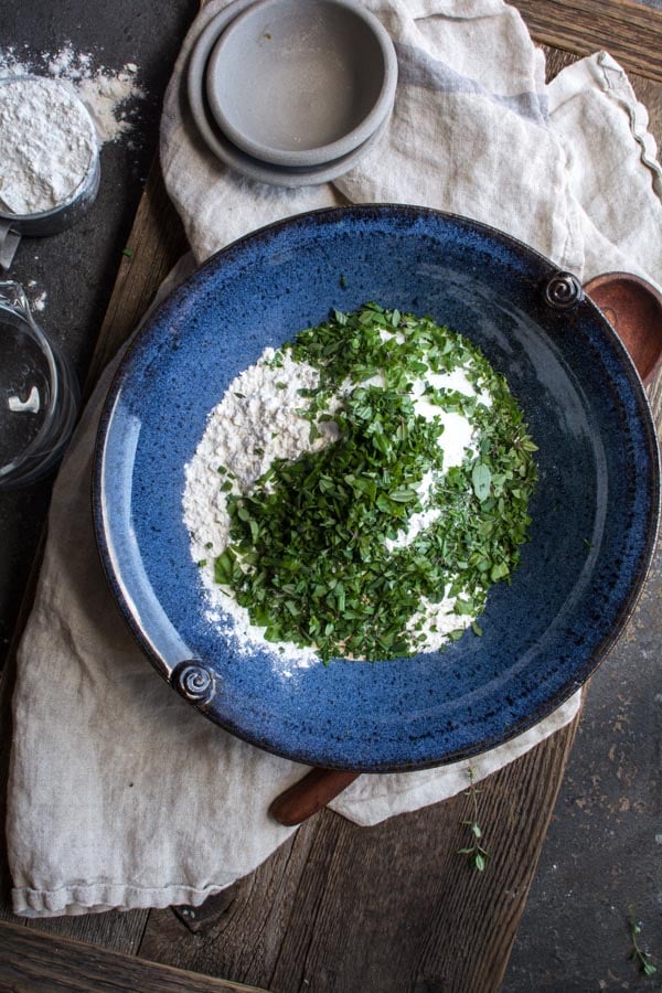 blue bowl with flour and fresh herbs on top