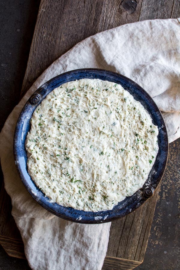 rising focaccia dough in blue bowl