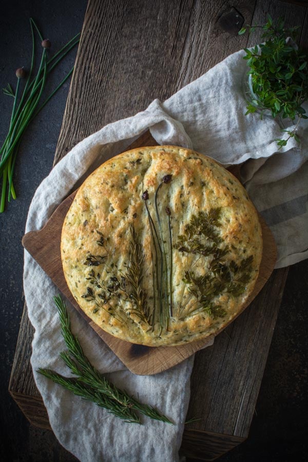 overhead view of herb focaccia bread on cutting board