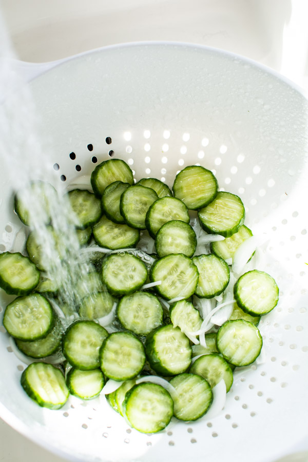 cucumbers and onions being rinsed with water