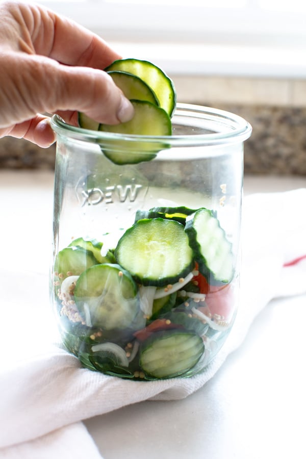 cucumbers, onion slices, an habanero peppers layered in clear glass jar