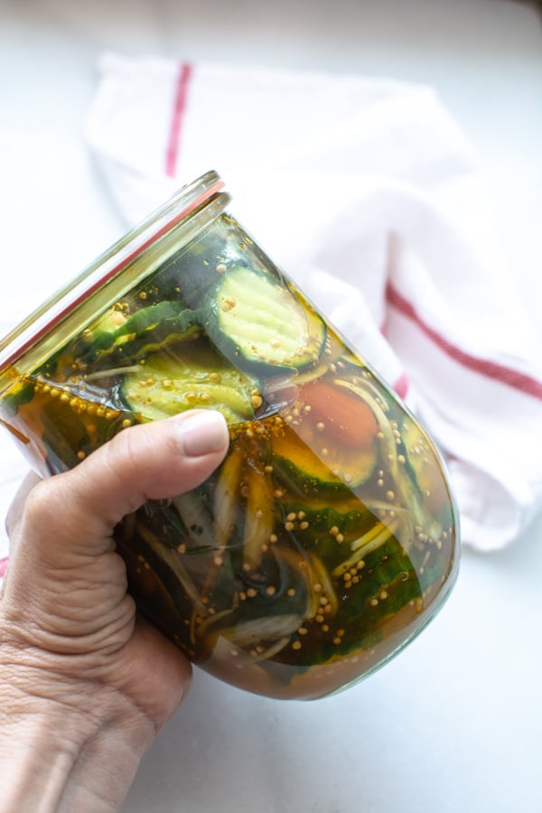 lid on jar of pickles being shaken to distribute pickles