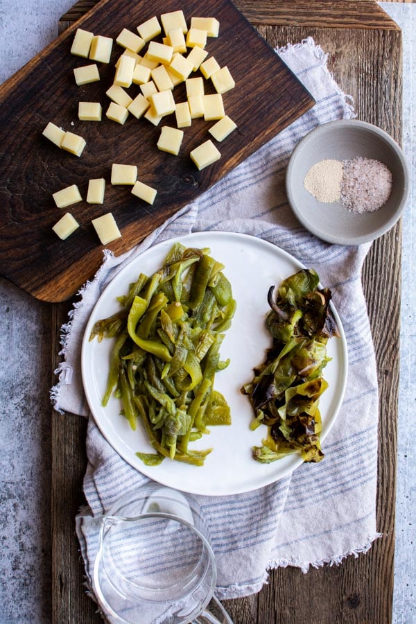 Peel roasted green chiles cut into strips on white plate