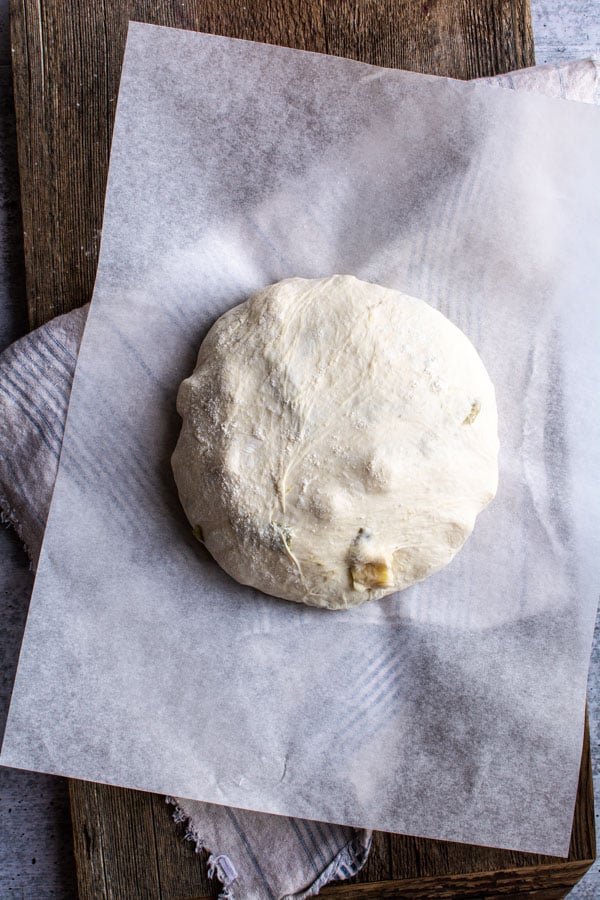 smooth kneaded bread dough on sheet of parchment paper