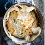 baked cheddar chile bread in blue pot with parchment paper