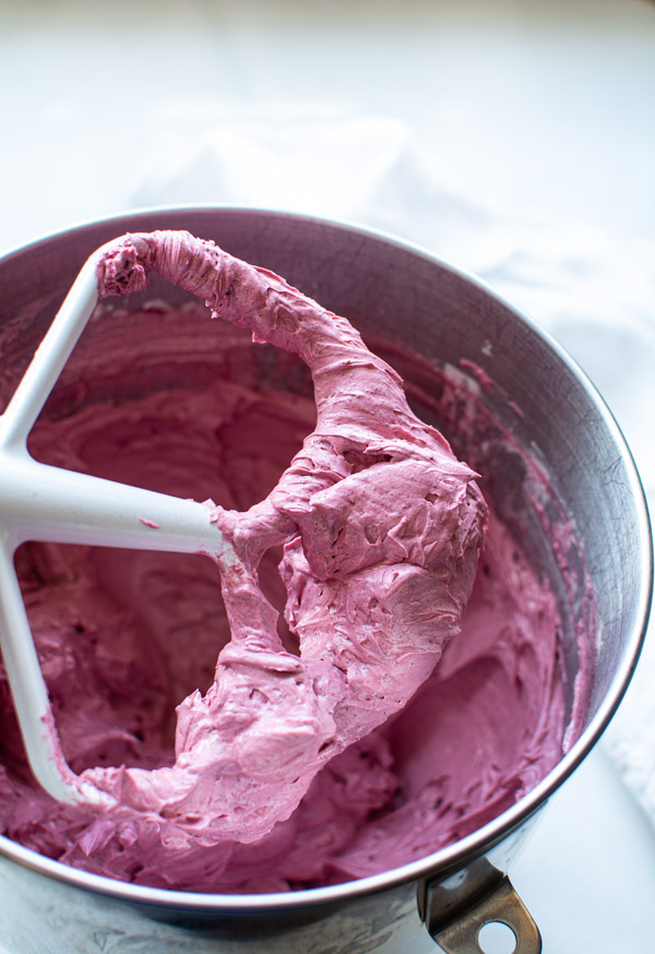 bright pink hibiscus buttercream in bowl showing beater covered with icing