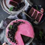 overhead shot of chocolate zucchini cake with hibiscus icing, 2 slices on plates