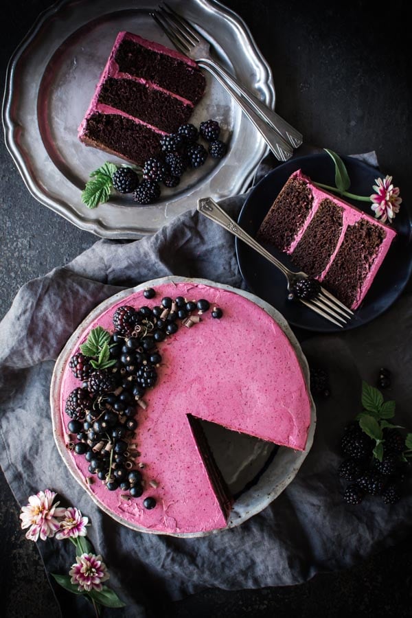 overhead shot of chocolate zucchini cake with hibiscus icing, 2 slices on plates