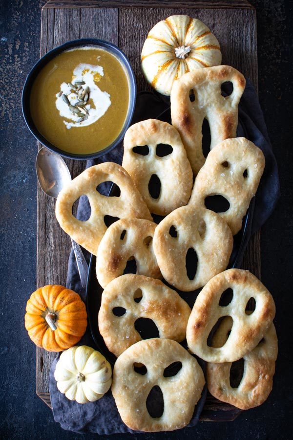 Ghost shaped fougasse on a black platter and wood background