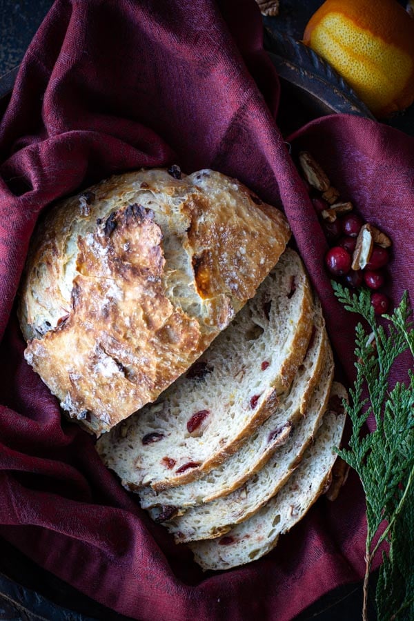 overhead shot of sliced cranberry orange pecan bread on a burgundy cloth