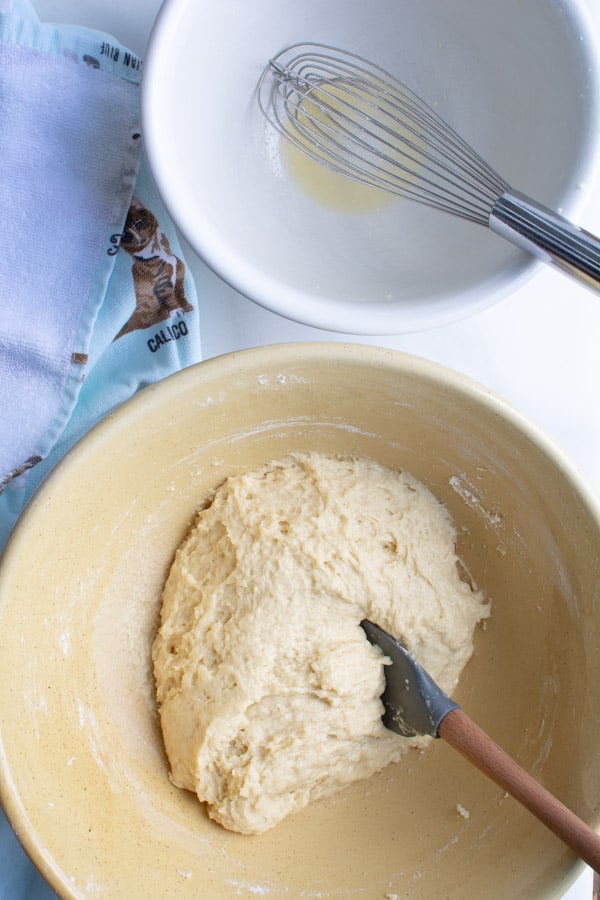 Formed dough in a yellow bowl, with spatual.