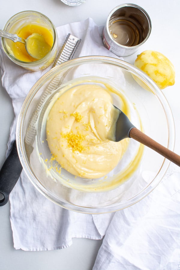 glass bowl with combined condensed milk and lemon curd with lemon zest