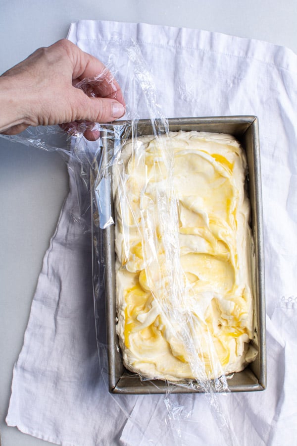 Plastic wrap covering pan with ice cream