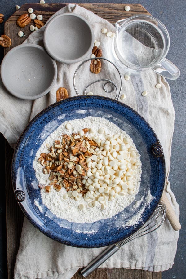 blue bowl with flour , pecans, white chocolate chips