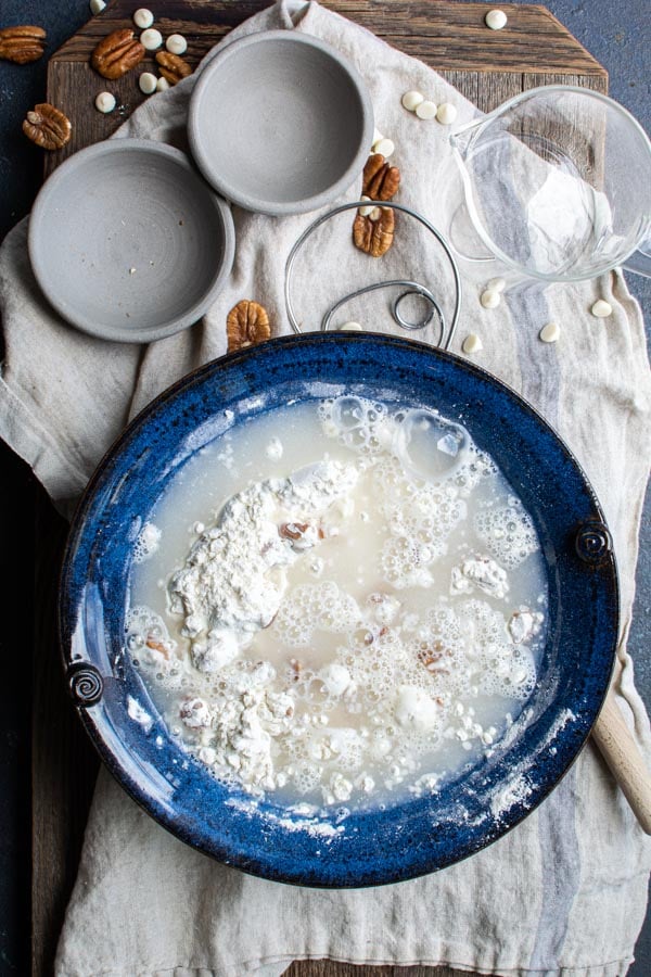 Water pour over flour mixture in blue bowl