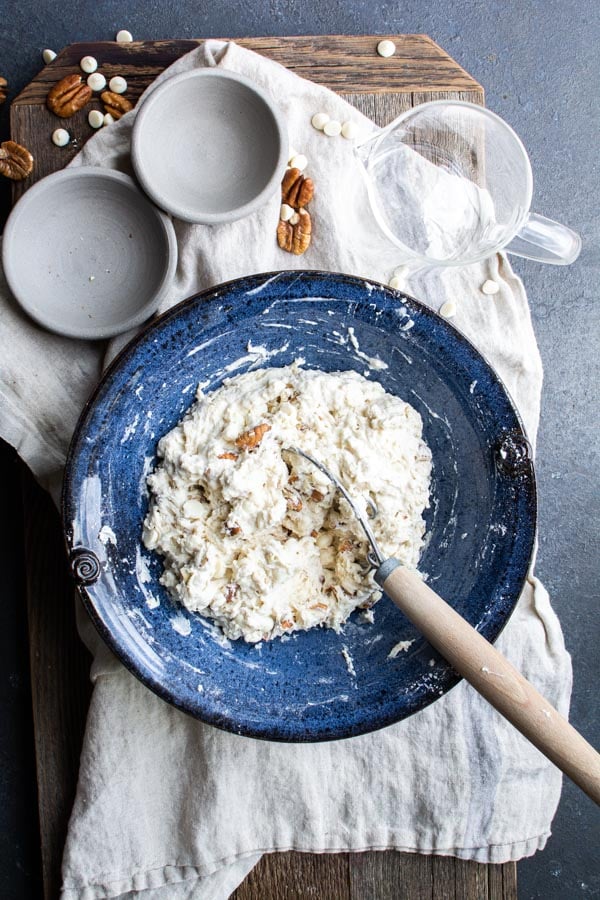 wooden dough kneader in mixed dough in blue bowl