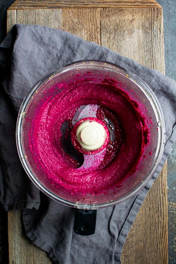 Food processor bowl with bright pink beet butter