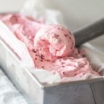 Quick and Easy Strawberry Ice Cream in a metal bread pan with an ice cream scoop