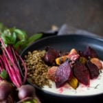 Black bowl with mint yogurt topped with roasted beets and chopped mint