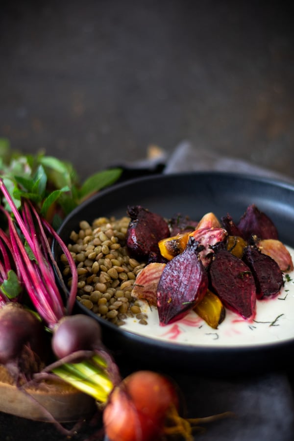 Black bowl with mint yogurt topped with roasted beets and chopped mint